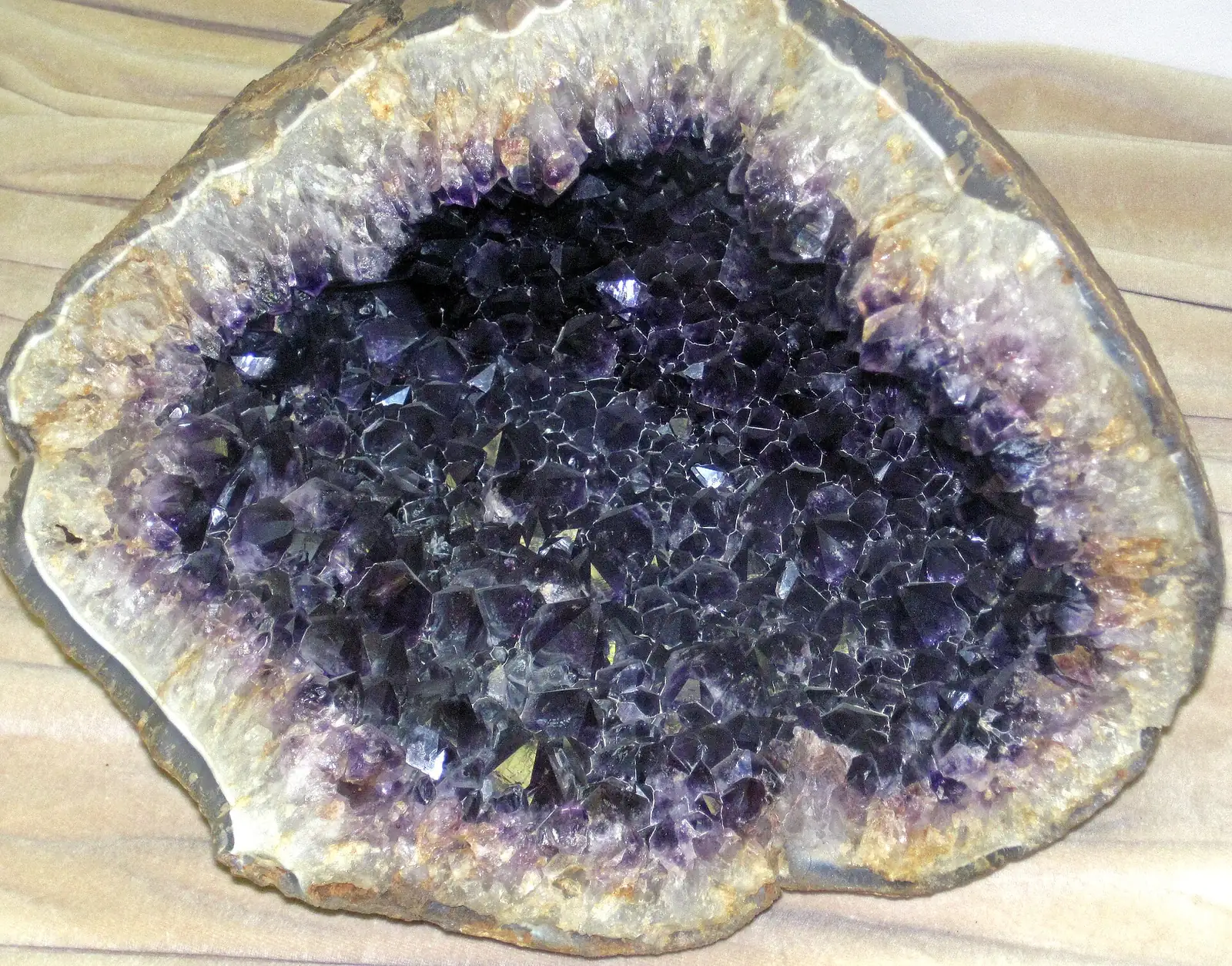 Geoda de ametista aberta, com cristais roxos dentro de uma casca de pedra clara