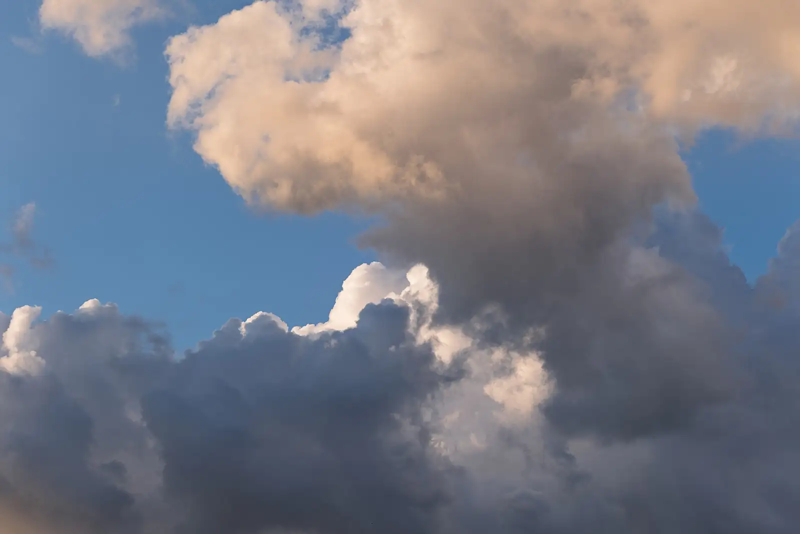 Céu azul com grandes nuvens brancas iluminadas pela luz dourada do fim do dia, em Ponte de Sor